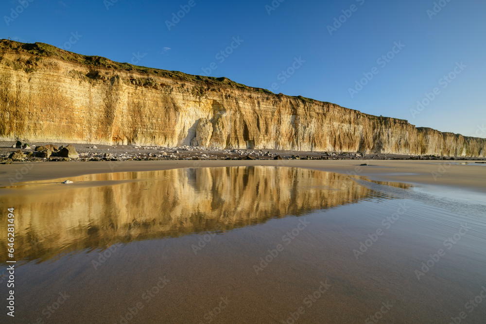 Reflection of chalk cliffs in water puddle at beach Reflection of chalk cliffs in water puddle at beach