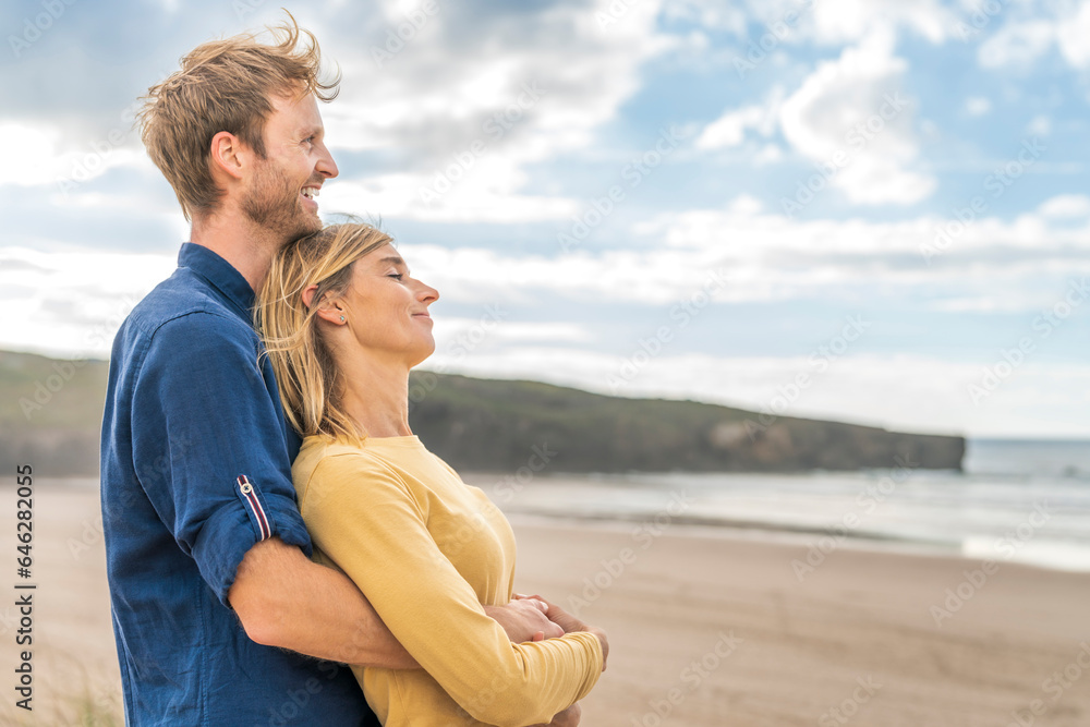 Happy man standing with woman at beach Happy man standing with woman at beach