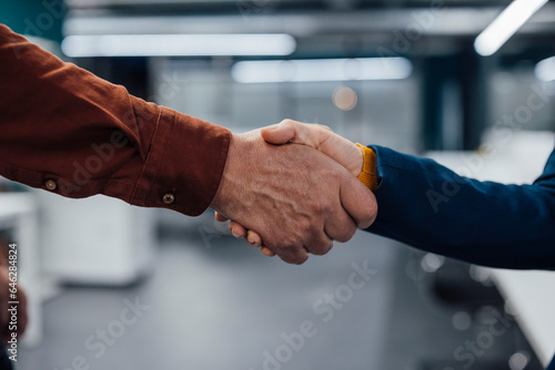 Hands of business colleagues shaking hands at work place photo