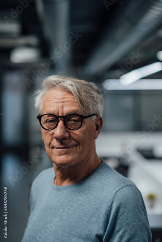 Senior businessman with grey hite hair wearing eyeglasses at work place
