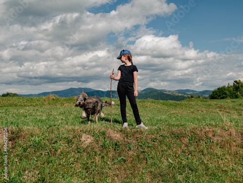Little girl with dogs Carpathian mountains peak in Zakarpattya village Ukraine Europe. Family walks with pets on scenic landscape green trees sunny day Eco Local countryside tourism Hiking Cottagecore