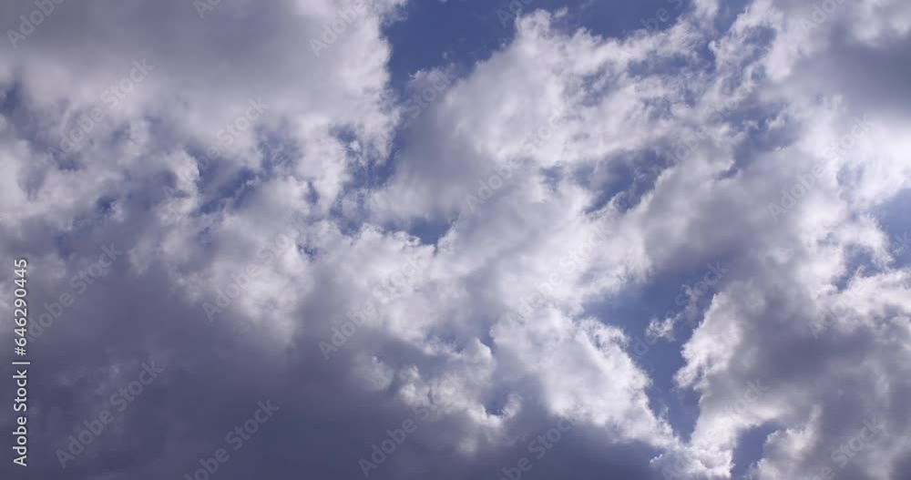 Clouds passing by from left to right with a blue sky in the background Clouds passing by from left to right with a blue sky in the background