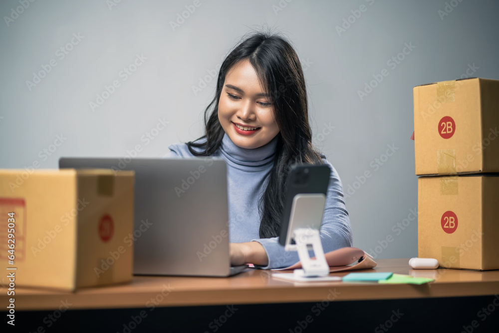 A Female entrepreneur, small business owner uses a laptop, she uses technology to sell products online over the internet.