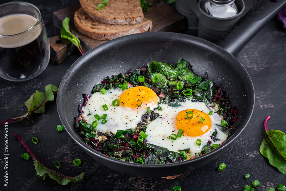 Breakfast. Fried eggs with green beet leaves, garlic, pepper and green onion in pan. Breakfast. Fried eggs with green beet leaves, garlic, pepper and green onion in pan.