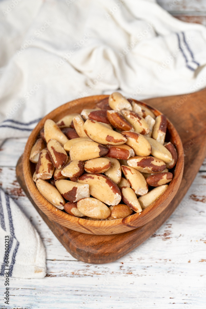 Brazil nut in wood bowl. Brazilian nuts peeled on white wood background. Close up Brazil nut in wood bowl. Brazilian nuts peeled on white wood background. Close up