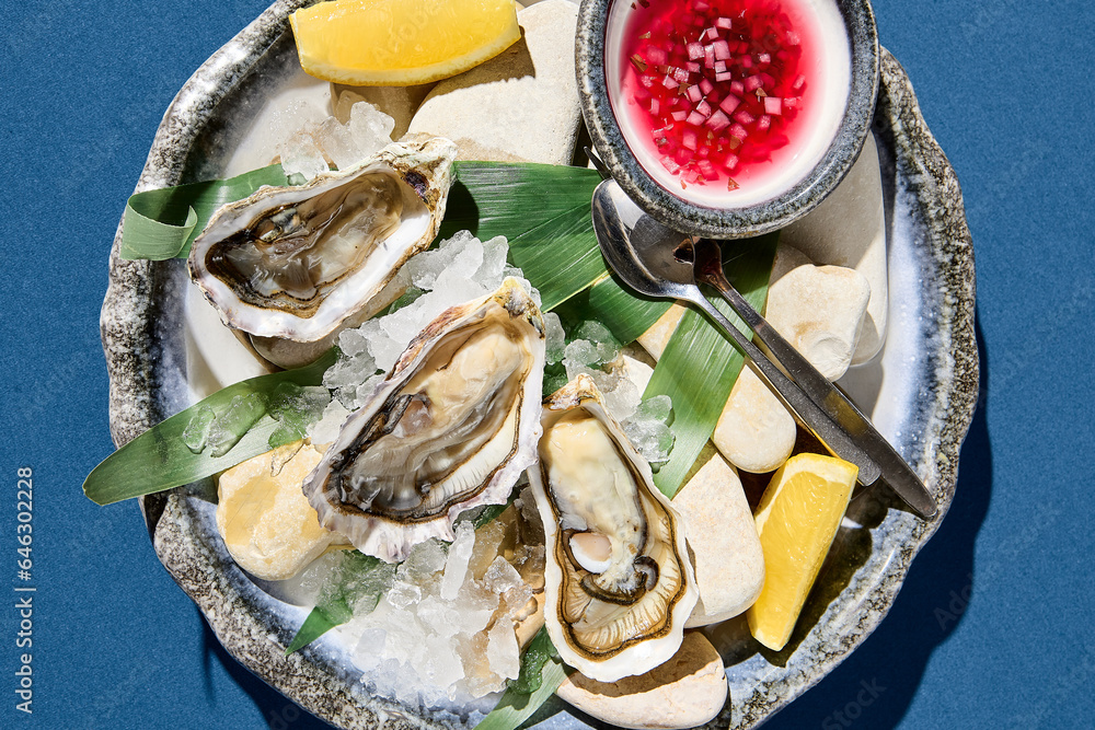 Horizontal top view of fresh oysters served on ice with lemon, an exquisite seafood dish setup. Horizontal top view of fresh oysters served on ice with lemon, an exquisite seafood dish setup.