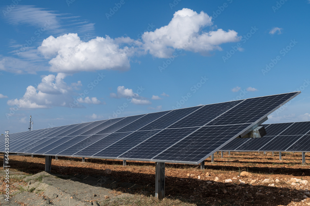 Vista de un huerto solar con placas fotovoltaicas y nubes al fondo. Vista de un huerto solar con placas fotovoltaicas y nubes al fondo.