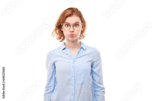 Vászonkép Portrait of young redhead woman puffing cheeks with funny face isolated on white studio background