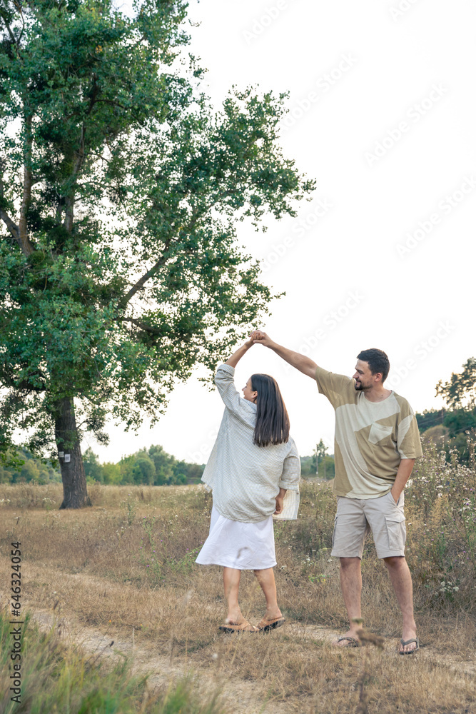 Fototapeta premium Playful and youthful adult man and woman having fun together in the meadow.