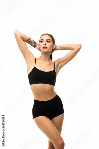 Laughing sporty woman in black bikini posing on grey background. Photo of attractive girl with slim toned body.