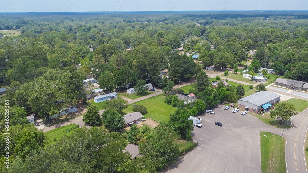 Row of manufactured, modular, and mobile homes surrounding by lush green trees in Richland, Rankin County, Mississippi suburb of Jackson, USA established neighborhood