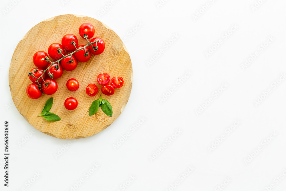 Fresh tomatoes and basil on cooking board, top view Fresh tomatoes and basil on cooking board, top view