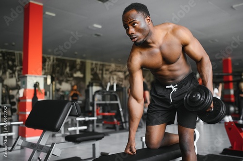 Fototapeta Naklejka Na Ścianę i Meble -  African American young man doing workout at the gym