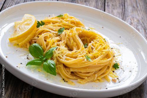 Linguine al limone - pasta with lemon and parmesan on wooden background 