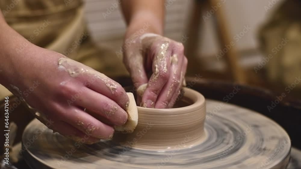 Potter girl works on potter's wheel, making ceramic pot out of clay in pottery workshop. Art and hobby concept. slow motion Potter girl works on potter's wheel, making ceramic pot out of clay in pottery workshop. Art and hobby concept. slow motion