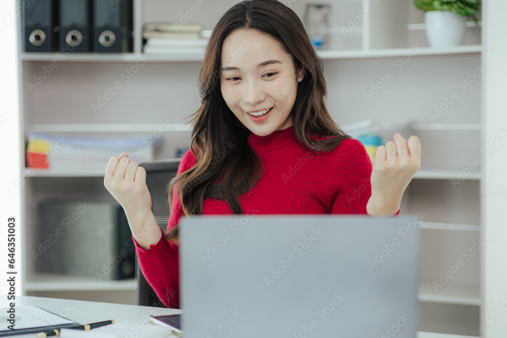 Beautiful Asian woman working on laptop in home office Beautiful Asian woman working on laptop in home office