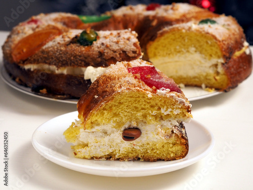 Close up of cake Roscon de Reyes with cream and a suprpise bean inside