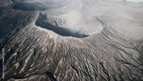 Mount Bromo active volcano landscape. Aerial orbit rotation looking into the volcanic smoking crater of this desert lifeless baron moon like surface.
