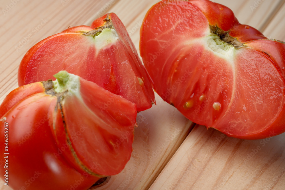 Red ripe sweet tomato on a wooden light table