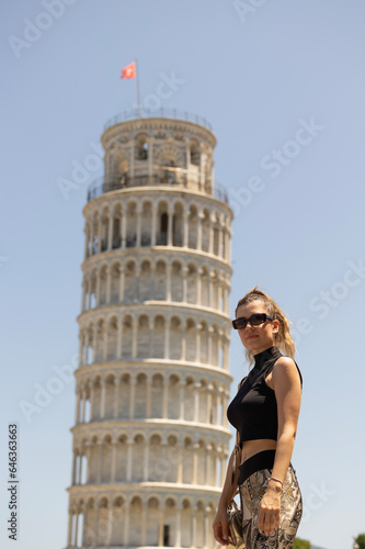 Young woman is posing in fornt of the Pisa Tower.