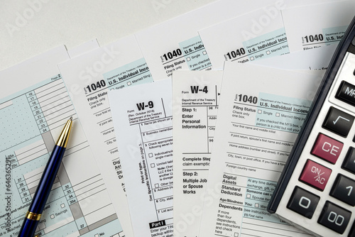 calculator on blank 1040 w4 w9 tax form 2022, taxation concept