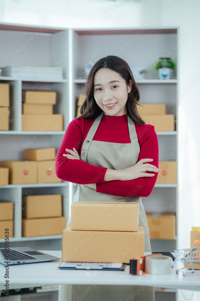 Starting a small business owner happy asian girl Smiling at sales success after checking orders from online shopping store using laptop and smartphone at home office. Concepts of online business and e Starting a small business owner happy asian girl Smiling at sales success after checking orders from online shopping store using laptop and smartphone at home office. Concepts of online business and e