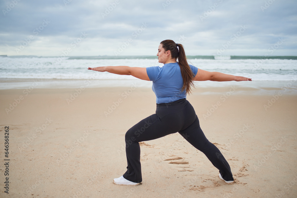 Caucasian plus size woman looking away while warming up at the sea beach Caucasian plus size woman looking away while warming up at the sea beach