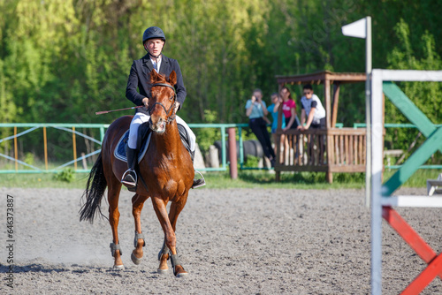 Young horseback sportsman on his course in showjumping competition
