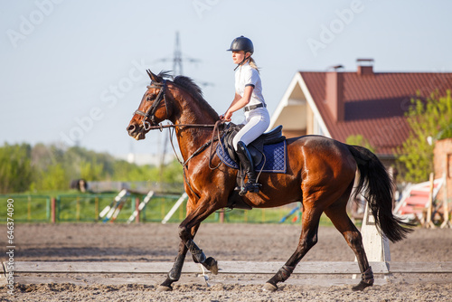 Young rider woman riding horse warming up before showjumping competition © skumer