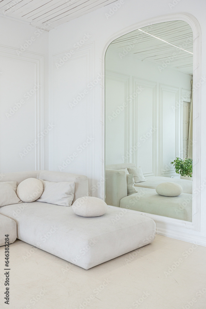 Fototapeta premium interior of a bright living room in a luxurious baroque style with white walls decorated with antique stucco