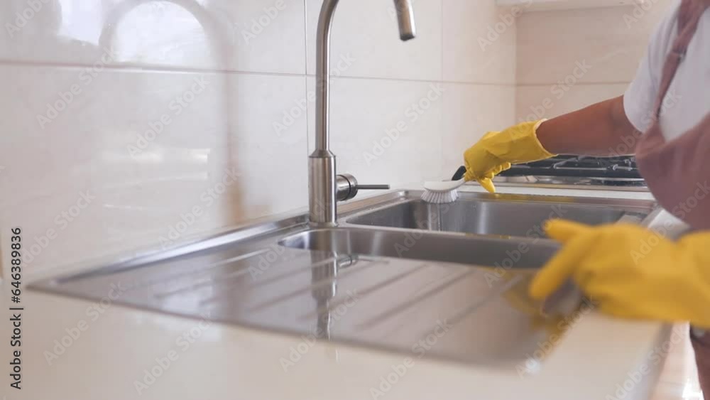Housewife 50s woman housekeeping on weekend.Woman in yellow protective rubber gloves cleaning kitchen cabinets with sponge. High quality FullHD footage Housewife 50s woman housekeeping on weekend.Woman in yellow protective rubber gloves cleaning kitchen cabinets with sponge. High quality FullHD footage