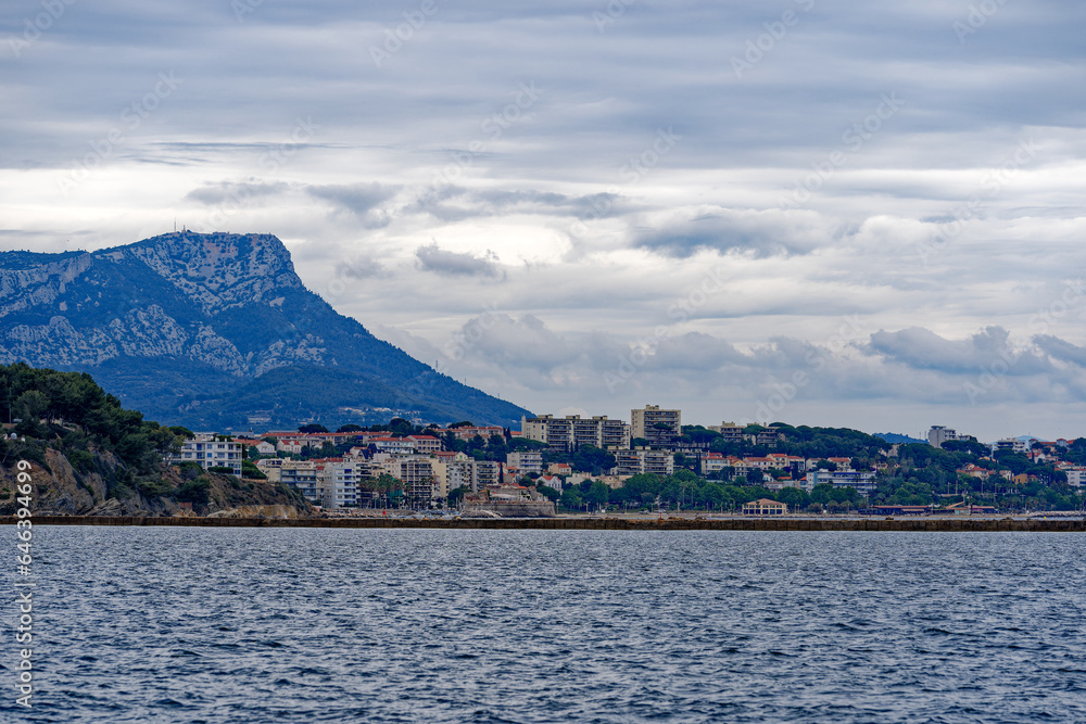 Bay of Mediterranean Sea with skyline of French City of Toulon on a cloudy late spring day. Photo taken June 9th, 2023, Toulon, France.