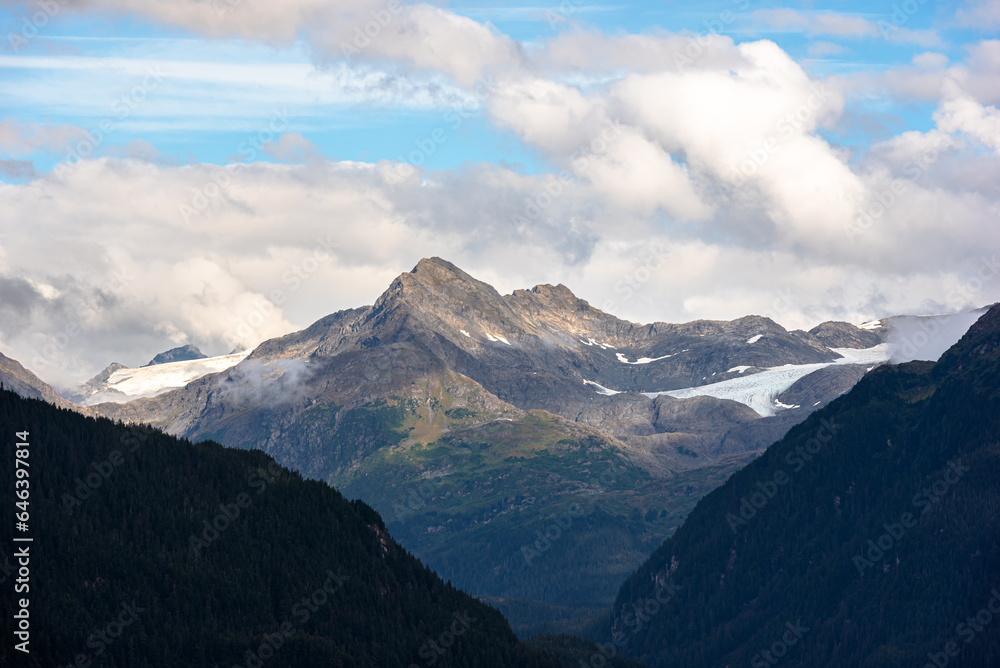 View of mountain peak surrounded by clouds in Alaska, USA. View of mountain peak surrounded by clouds in Alaska, USA.