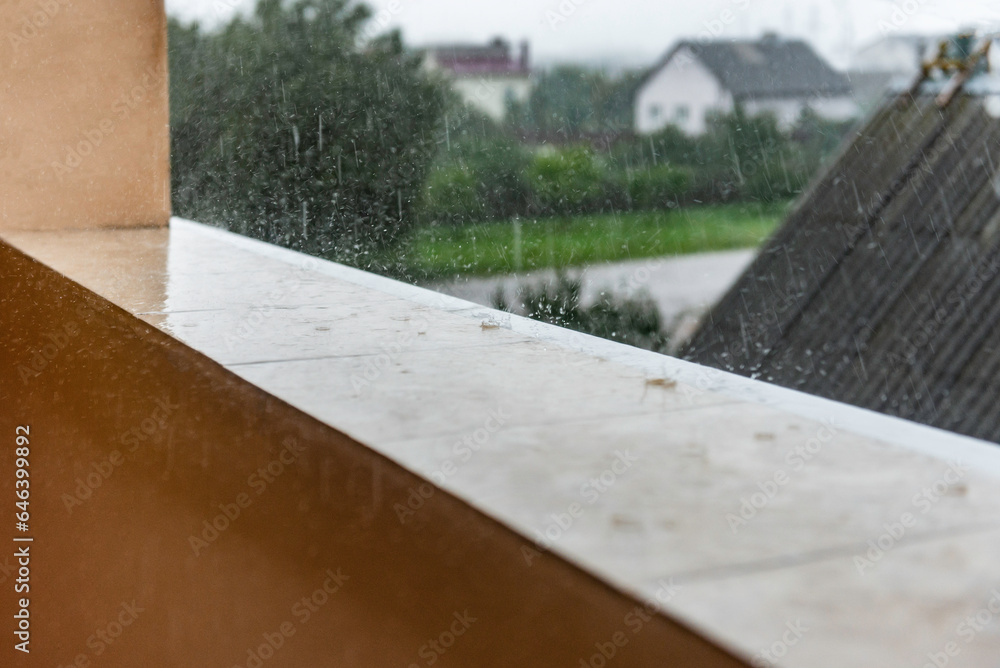 Raindrops fall on the wet tiles of an open, unglazed balcony. Raindrops fall on the wet tiles of an open, unglazed balcony.