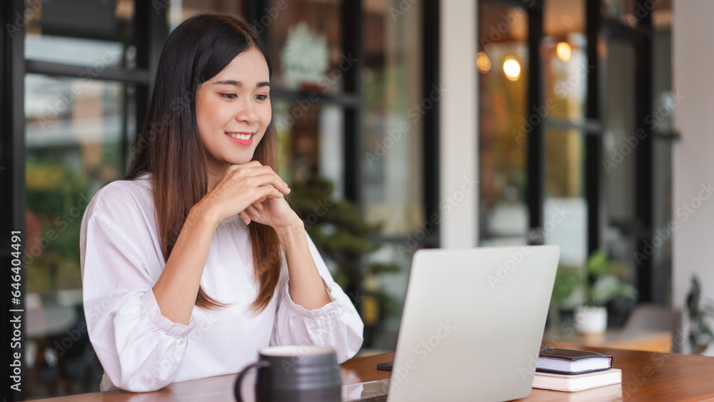 Businesswomen reading data on laptop to analysis about new startup while working in outside office Businesswomen reading data on laptop to analysis about new startup while working in outside office