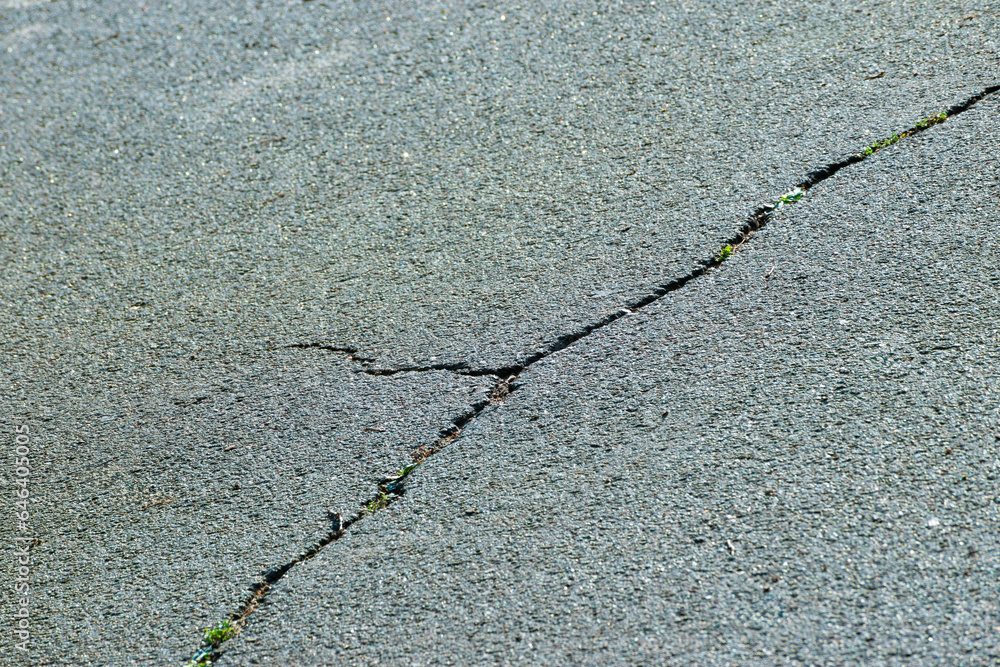 Obraz premium cracks in the asphalt. the concept of the need to repair the roadway