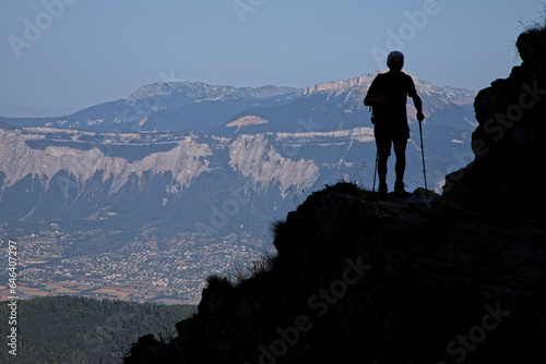 ST-AGNES, FRANCE, August 24, 2023 : Hiker walks in the shadows of slopes of Belledonne mountain range near Refuge Jean collet with Chartreuse summits on background