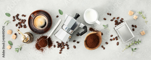 Flat lay with Moka pot, espresso cup, ground coffee, milk, sugar and coffee beans on a grey concrete background