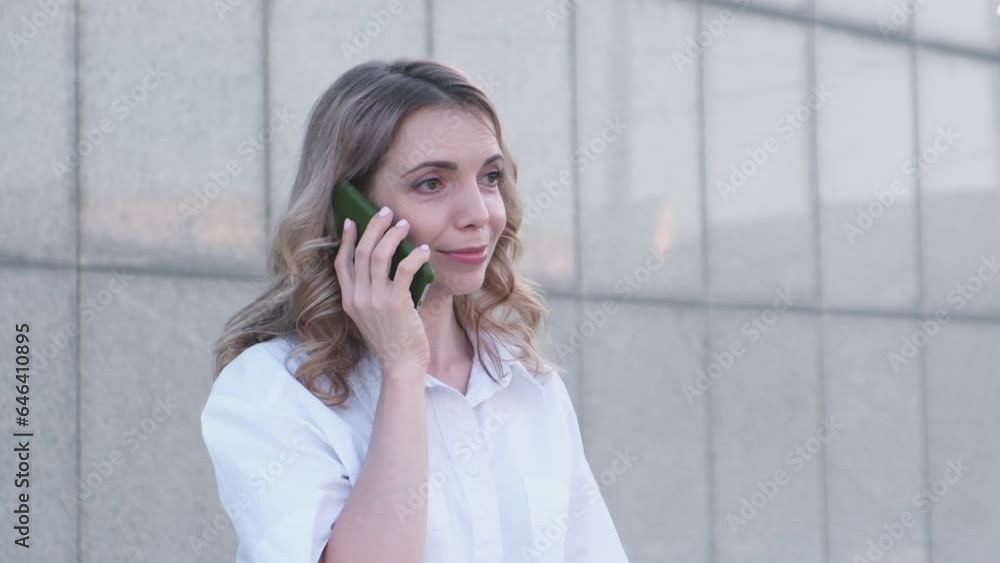 a fasion pretty bisness woman is calling someone by mobile phone outdoor. a fasion pretty bisness woman is calling someone by mobile phone outdoor.