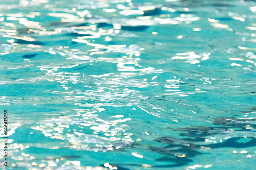 reflections on the water of a swimming pool with yellow balls where swimming ball is played
