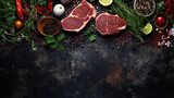 Overhead shot of meat accompanied by herbs against a dark backdrop.