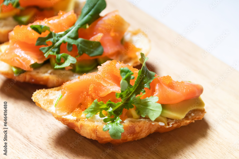 Smoked salmon with cream cheese and avocado slide on fresh croissants. Smoked salmon with cream cheese and avocado slide on fresh croissants.
