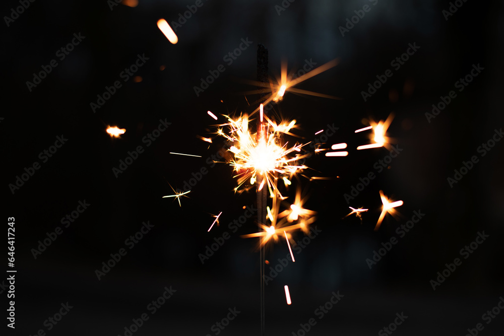 Obraz premium photography, sparkler close-up on a dark background, holiday lights