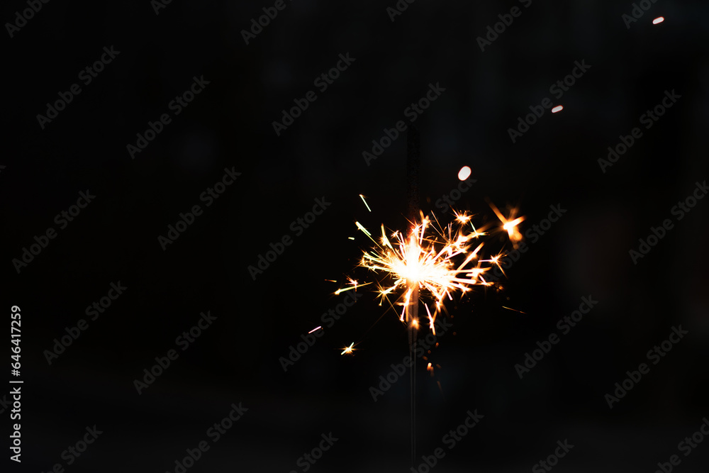 Obraz premium photography, sparkler close-up on a dark background, holiday lights 