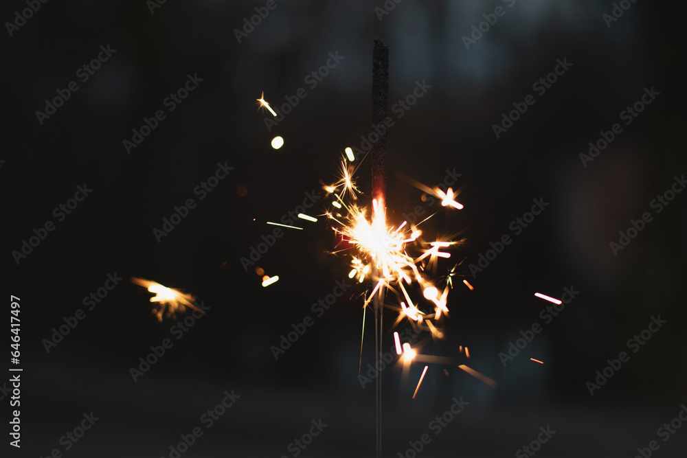 Obraz premium photography, sparkler close-up on a dark background, holiday lights 