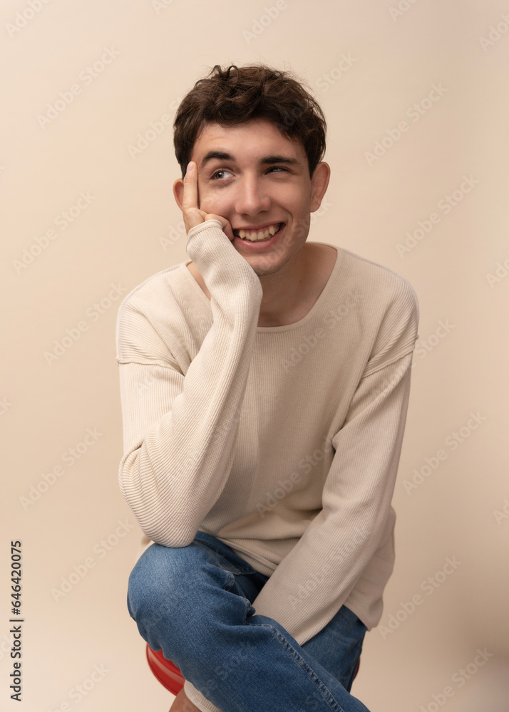 portrait of a young man in a light pullover posing for the camera, different emotions, on a light background portrait of a young man in a light pullover posing for the camera, different emotions, on a light background