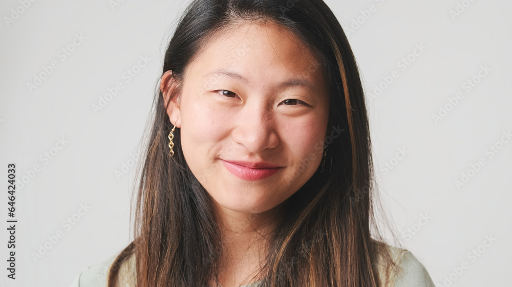 Close-up, girl in gray top, looks at the camera and smiles, isolated on white backgroun Close-up, girl in gray top, looks at the camera and smiles, isolated on white backgroun