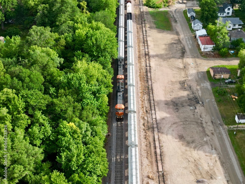 Train running through town on a summer's day. Train running through town on a summer's day.