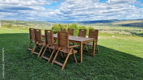 Wooden table and chairs  on green meadow  in summer day.