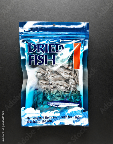 getrockneter Fisch in einer Plastiktüte auf schwarzem Hintergrund photo